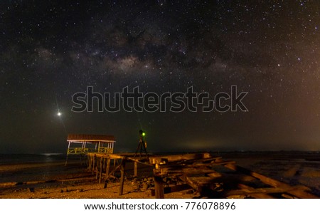 Venus rising with milky way on top with a camera on Jetty at Kg Jangkit, Kuala Penyu, Sabah. Image contains visible noise due to high ISO, soft focus & slight motion blur.
