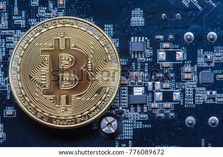 bitcoin symbol coin on a blue computer circuit board motherboard