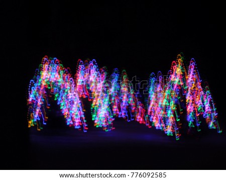 Colored Christmas Lights on Pine Trees Dancing in the Night Sky Creating an Abstract Pattern Light Show in the Snow