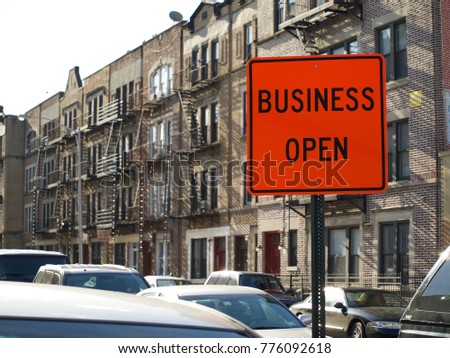 Orange Construction Business Open Sign in front of Real Estate