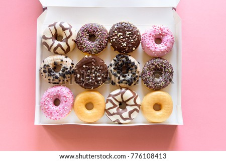One dozen colorful glazed donuts decorated with pretty sprinkles Royalty-Free Stock Photo #776108413