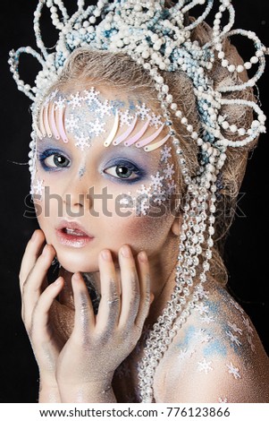 close up portrait of beautiful girl. professional winter makeup. hair in snow