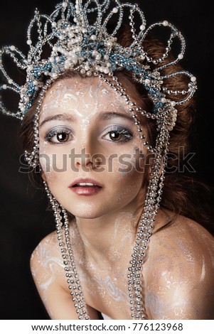 close up portrait of beautiful girl with crown on black background. professional winter makeup