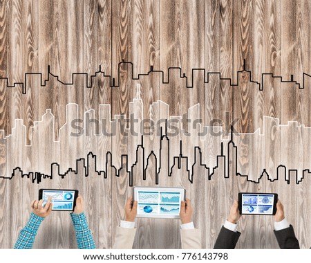 Group of three people with devices in hands working together as symbol of networking and communication