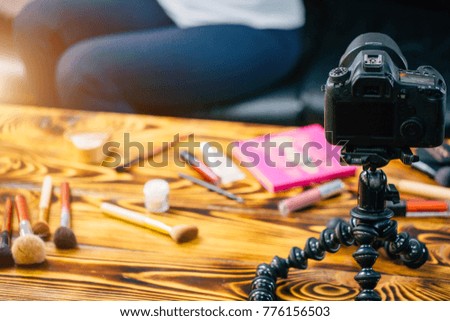 Young female blogger on camera screen doing makeup from client