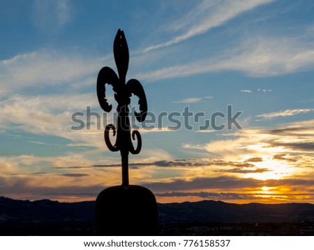 The wrought iron lily of Gubbio at sunset