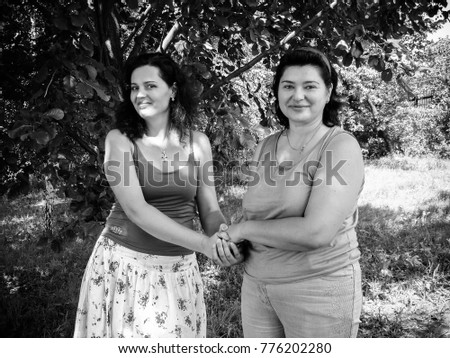 Two mature american woman friends speaking in park about life. Black and white vintage style photo