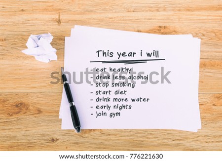 This year i will phrase written on paper with pen. Retro style wooden background. 