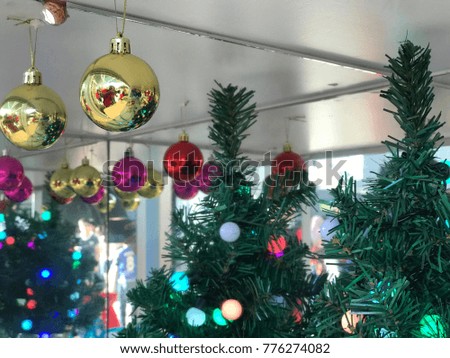 Christmas decoration ball and tree near a mirror.