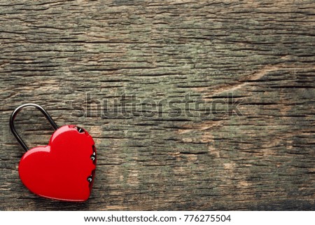 Heart shaped padlock on grey wooden table