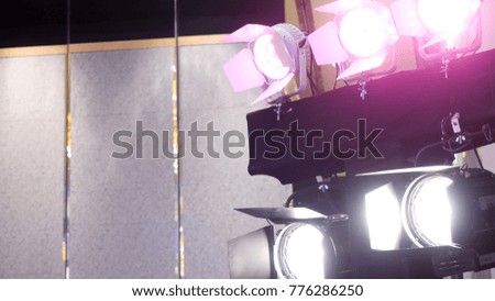 Theater spot light with smoke against wall. Spotlight, illuminator, lamp