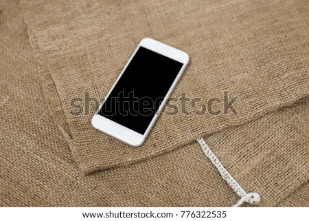 Mock up image of white phone on burlap texture