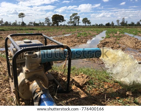 water flows from a pipe or water gushing out of the pipe close up from large pump tube in rice field in central Royalty-Free Stock Photo #776400166