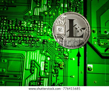 Silver Litecoin coin on a green circuit board background.