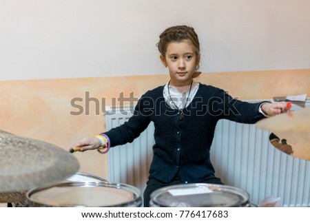 young caucasian teenage girl plays the drums