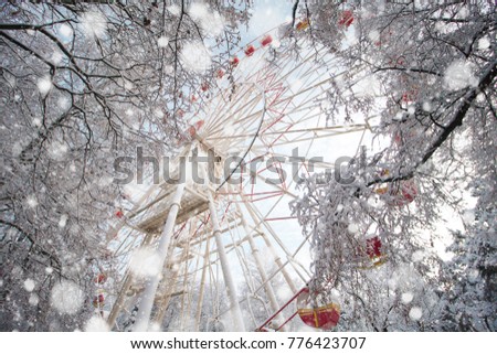 The Ferris wheel in the park in winter is covered with snow, a beautiful winter frosty day, snowfall
