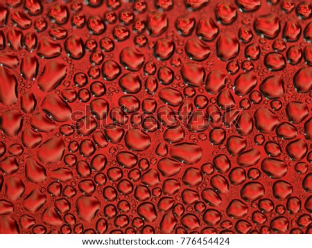 Drops of water on the glass, in different colors (red)