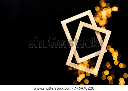 Two wooden picture frames twist overlay. Double exposure, glitter bokeh light rise up on black color background