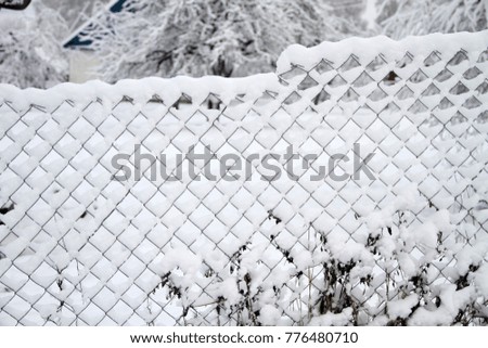 Abstract image of chain link fence with snow. Steel gate fence with snow design. Winter season view of industrial steel fence. 