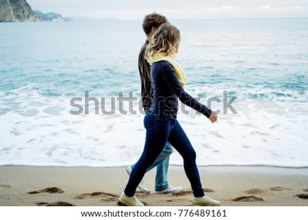 Young couple walking along the sea in autumn, Montenegro. unfocused photo