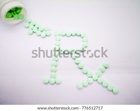 Pharmacy symbol, Rx word made by light green tablets isolated on white background. copy space and selective focus.