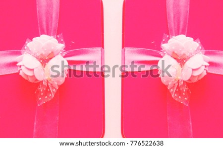 Pink gifts box on soft pink background. Reflection of sides.
