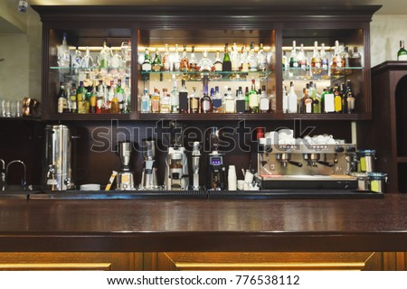 Bar counter with alcohol bottles assortment. Barroom in restaurant, hotel, pub copy space. Cafe background Royalty-Free Stock Photo #776538112