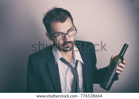 Disheveled bearded man in suit with a bottle