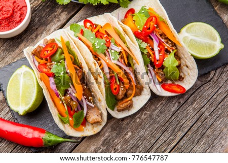 Three Mexican tacos with meat and vegetables. Top view. 