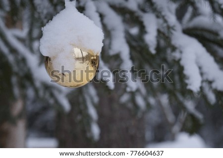 Christmas ball outdoors covered with snow