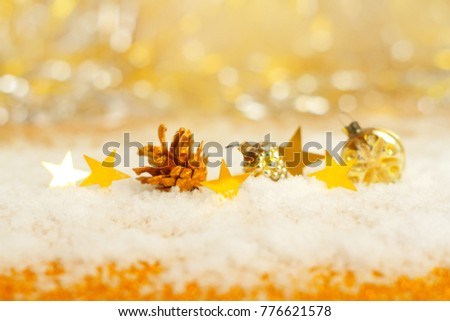 Golden stars in the snow and golden toy