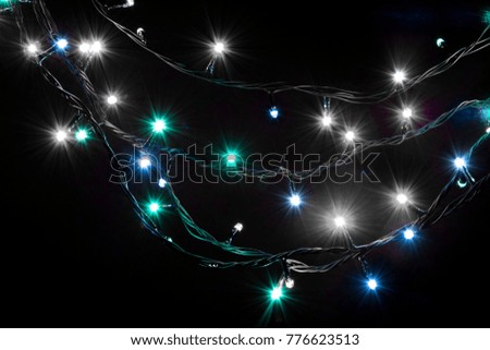 Christmas romantic lights frame on black background with copy space. Decorative garland in night space. Clear perfect beautiful decoration for intimate evening dinner. Studio close up photo. 