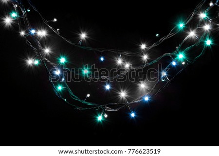 Christmas romantic lights frame on black background with copy space. Decorative garland in night space. Clear perfect beautiful decoration for intimate evening dinner. Studio close up photo. 