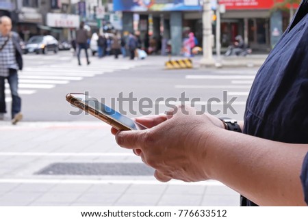 Motion of woman crossing street and using mobile phone in Taipei Taiwan