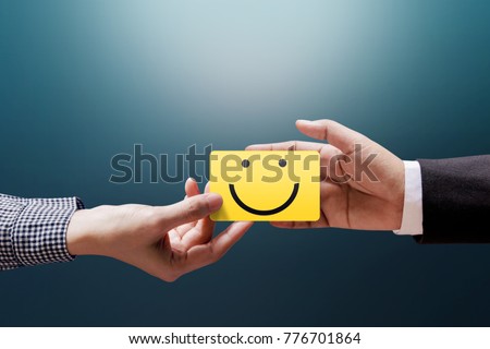 Customer Experience Concept, Happy Client Woman giving a Feedback with Happy Smiley Face Card into a Hand of Businessman Royalty-Free Stock Photo #776701864