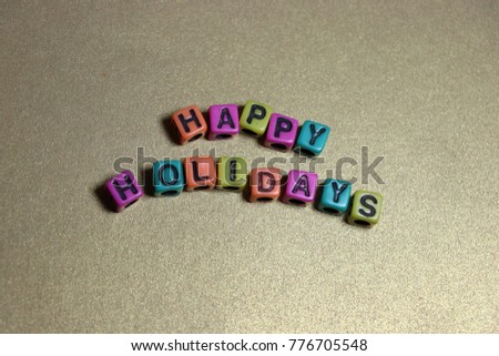 Merry Christmas Happy Holidays Peace on Earth words and letters spelled with colorful alphabet bead blocks.