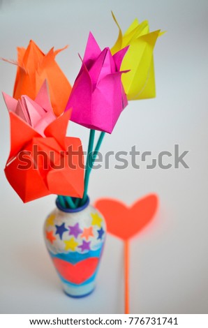 Multicolored tulips handmade from paper by March 8 on a light background