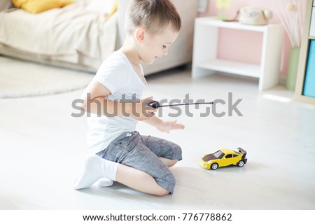 a boy playing with a car remote