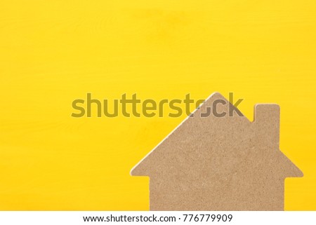 Image of wooden house model over yellow background. Real estate concept