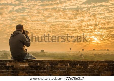 Male traveler photographing temples at Bagan Myanmar Asia at sunrise