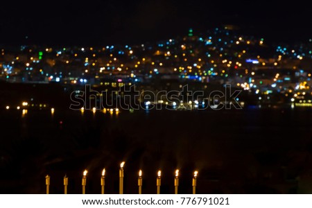 Burning candles are traditional symbol for Hebrew Holidays and celebration of bright Hanukkah. Background of night sky, selective focus