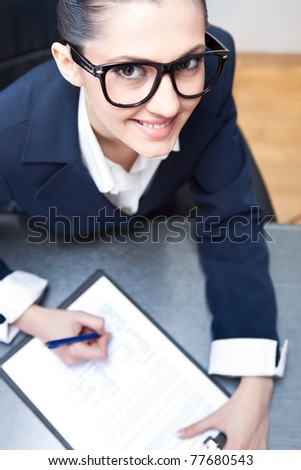 pretty secretary taking notes at office desk, top view