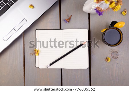 Notebook, coffee and flowers for female home or office workplace on wooden background. top view. Copy space.