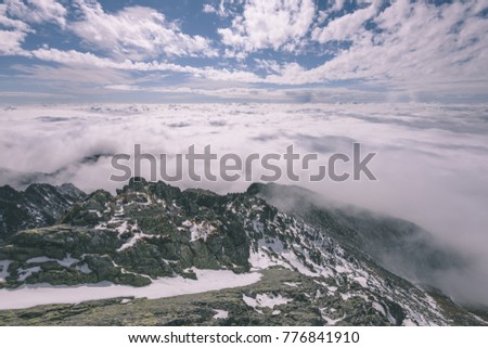 western carpathian mountain tops in  autumn covered in mist or clouds. panoramic view from a distance- vintage effect