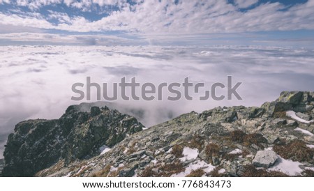 mist covered mountains with blue sky and tourist trails in slovakia - vintage film look