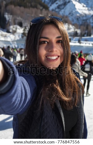 Beautiful woman on skates taking a selfie , mountains in the background