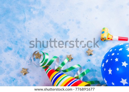 Bright colorful carnival or party scene of balloons, streamers and confetti on blue table. Flat lay style, birthday or party greeting card with copy space.