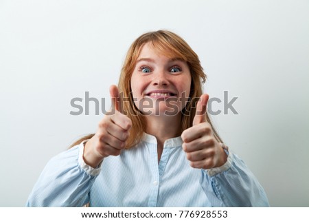 Headshot of pretty and funny red-headed girl smiling and showing big thumbs up feeling enthusiastic and satisfied with a good offer.