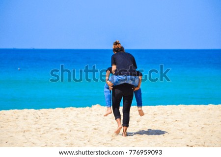 Two girls riding back at the beach.