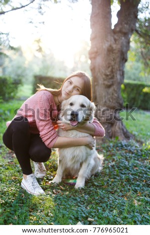 Photo of girl hugging dog on lawn